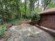 Concrete patio area adjacent to a brick home with a glimpse of the wooded backyard at 2226 Medfield Ne Trl, Atlanta, GA 30345