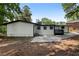 View of the home's rear exterior and expansive backyard surrounded by lush trees at 4720 Shoshonee Trl, College Park, GA 30349