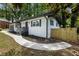 Landscaped front yard featuring a bright white home with contrasting dark trim, walkway and fence at 4720 Shoshonee Trl, College Park, GA 30349