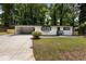 Charming single-story home with white brick, dark trim, front yard, and open carport at 4720 Shoshonee Trl, College Park, GA 30349