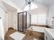 Bathroom showcasing a walk-in glass shower and large tub with travertine surround, and modern fixtures at 9195 Tuckerbrook Ln, Alpharetta, GA 30022