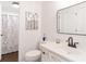 Clean bathroom featuring a vanity, framed mirror, and a shower/tub with a patterned curtain at 9195 Tuckerbrook Ln, Alpharetta, GA 30022