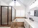 Bathroom showcasing a glass shower and large tub with travertine surround, shutters, and modern fixtures at 9195 Tuckerbrook Ln, Alpharetta, GA 30022