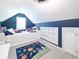 Bedroom featuring blue accent wall, built-in drawers, a cozy window seat, and a playful space-themed rug at 9195 Tuckerbrook Ln, Alpharetta, GA 30022