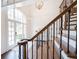 Elegant staircase with wrought iron spindles, with a view to the front doors and the lovely gardens beyond at 9195 Tuckerbrook Ln, Alpharetta, GA 30022