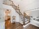 Elegant foyer featuring hardwood floors, a staircase with iron spindles, and views into the kitchen and living room at 9195 Tuckerbrook Ln, Alpharetta, GA 30022