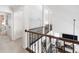 Hallway with decorative railing overlooks a living room with a fireplace and abundant natural light at 9195 Tuckerbrook Ln, Alpharetta, GA 30022