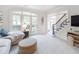 Bright and airy living room with large windows, a comfortable couch, and access to the foyer at 9195 Tuckerbrook Ln, Alpharetta, GA 30022