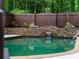 Backyard pool with waterfall feature and stone accents, providing a luxurious outdoor space at 9195 Tuckerbrook Ln, Alpharetta, GA 30022