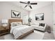 Stylish bedroom offers neutral tones, a ceiling fan, and a cozy couch for relaxation at 131 Prominence Ct, Canton, GA 30114