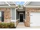 Charming brick home with a black front door, gray siding, and a well-maintained yard and white garage door at 131 Prominence Ct, Canton, GA 30114