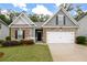 Charming home featuring a brick and siding facade, well-manicured lawn, and attached two-car garage at 131 Prominence Ct, Canton, GA 30114