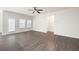 Large open living room with wood-look floors, a ceiling fan, and multiple windows at 131 Prominence Ct, Canton, GA 30114