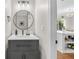 Stylish powder room featuring a gray vanity with a round mirror and modern lighting fixtures at 208 Magnolia Leaf Dr, Woodstock, GA 30188