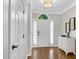 Bright entryway showcasing a hardwood floor, white front door, and a stylish cabinet at 208 Magnolia Leaf Dr, Woodstock, GA 30188