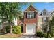 Charming two-story brick townhome with attached garage and manicured landscaping at 208 Magnolia Leaf Dr, Woodstock, GA 30188