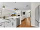 Open-concept kitchen with island seating, stainless steel appliances, and view to the living area and fireplace at 208 Magnolia Leaf Dr, Woodstock, GA 30188