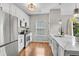 Well-lit kitchen with stainless steel appliances, white cabinetry, and a window with natural light at 208 Magnolia Leaf Dr, Woodstock, GA 30188