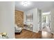 Chic home office with stone accent wall, stylish desk, and doorway to the primary bedroom at 208 Magnolia Leaf Dr, Woodstock, GA 30188