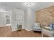 Stylish office nook with stone accent wall, decorative chair, and view to the hallway at 208 Magnolia Leaf Dr, Woodstock, GA 30188