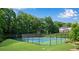 A blue and green fenced in community tennis court, with a townhouse in the background at 208 Magnolia Leaf Dr, Woodstock, GA 30188