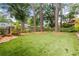 Serene backyard featuring lush green lawn, mature trees, and privacy fencing at 2217 Virginia Ne Pl, Atlanta, GA 30305