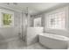 Elegant bathroom featuring a glass shower, a soaking tub, and a decorative stained-glass window at 2217 Virginia Ne Pl, Atlanta, GA 30305