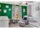Cozy green Bedroom featuring a crib, comfortable chair with ottoman, and whimsical tree-themed curtains at 2217 Virginia Ne Pl, Atlanta, GA 30305
