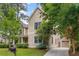 Exterior side view of a two-story home with a detached garage, lush landscaping, and a well-maintained lawn at 2217 Virginia Ne Pl, Atlanta, GA 30305