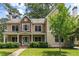 Charming two-story home featuring stone accents, a covered porch, lush landscaping, and a well-manicured lawn at 2217 Virginia Ne Pl, Atlanta, GA 30305