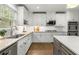 A well-lit kitchen with white cabinets, granite countertops, stainless steel appliances, and hardwood floors at 2217 Virginia Ne Pl, Atlanta, GA 30305