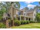 Rear exterior view of home with covered porch, stone accents, lush landscaping, and manicured lawn at 2217 Virginia Ne Pl, Atlanta, GA 30305