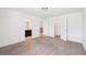 A carpeted floor and light walls fill this ample bedroom with an open door and walk-in closet at 2450 Overlook Ave, Lithonia, GA 30058