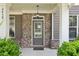Close-up of the front porch featuring a stylish brick facade, elegant lighting, and inviting entrance door at 2450 Overlook Ave, Lithonia, GA 30058