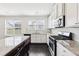 Bright kitchen with white cabinets, granite countertops, stainless appliances, and a center island, ideal for cooking at 2450 Overlook Ave, Lithonia, GA 30058