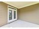 Covered patio showcasing tan siding, white trim, and French doors leading to backyard at 2450 Overlook Ave, Lithonia, GA 30058