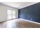 Bright bedroom with hardwood floors, blue accent wall, and window with natural light at 1130 Timbercreek Ct, Alpharetta, GA 30005
