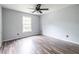 Bedroom with wood floors, ceiling fan, and large window at 1130 Timbercreek Ct, Alpharetta, GA 30005