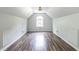 Bright bedroom featuring tray ceilings, large window, wood-look floors and white walls at 1130 Timbercreek Ct, Alpharetta, GA 30005