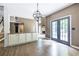 Open dining room featuring hardwood floors, a modern chandelier, and access to an outdoor patio at 1130 Timbercreek Ct, Alpharetta, GA 30005
