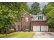 Charming two-story brick home with a two-car garage, manicured lawn, and traditional architectural details at 1130 Timbercreek Ct, Alpharetta, GA 30005