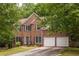 Charming two-story brick home with a two-car garage, manicured lawn, and traditional architectural details at 1130 Timbercreek Ct, Alpharetta, GA 30005
