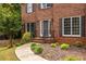 Brick home featuring a walkway leading to the front door with black shutters and manicured landscaping at 1130 Timbercreek Ct, Alpharetta, GA 30005