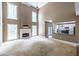 Bright living room with high ceilings, a fireplace, and an open view into the adjacent kitchen at 1130 Timbercreek Ct, Alpharetta, GA 30005