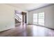 Living room featuring hardwood floors, a large window and entry to stairs and entryway at 1130 Timbercreek Ct, Alpharetta, GA 30005
