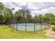 Fenced community tennis courts surrounded by lush green trees and clear blue skies at 1130 Timbercreek Ct, Alpharetta, GA 30005