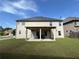 Back exterior view showcasing an extensive lawn, a covered patio, and the home's beige siding at 3488 Woodshade Dr, Loganville, GA 30052