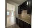 Bar area featuring dark cabinets, granite countertops, and a wine rack at 3488 Woodshade Dr, Loganville, GA 30052