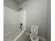 Bathroom featuring a white shower-tub combination with black hardware and matching toilet at 3488 Woodshade Dr, Loganville, GA 30052