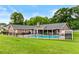Backyard featuring a pool, well-kept lawn, and brick house with covered patio, surrounded by a black metal fence at 4010 Hamilton Mill Rd, Buford, GA 30519